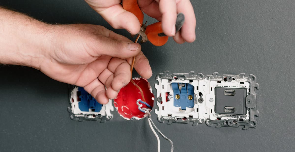 Elektrikerhand monterar uttag
